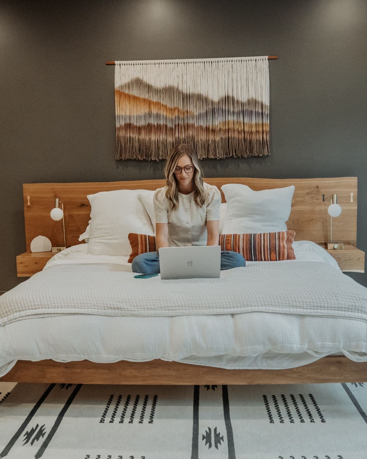 A parent working on a laptop in bed