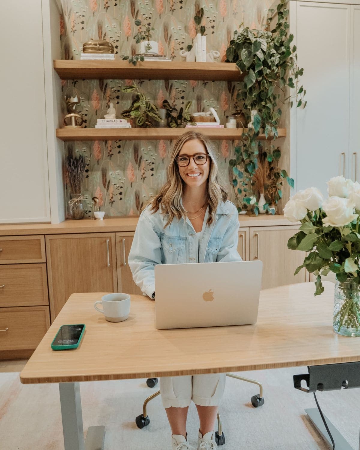 A woman working at a laptop in a home office