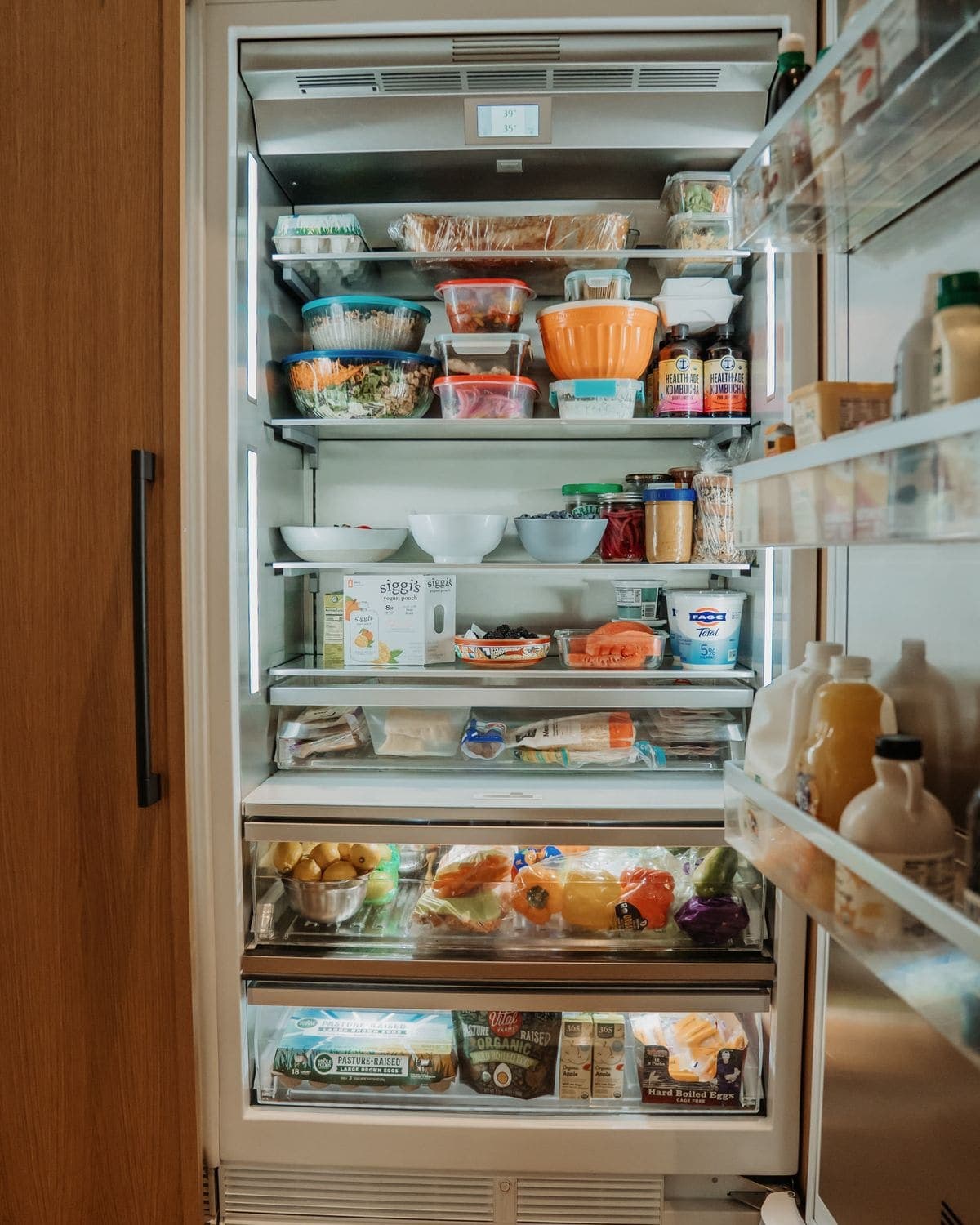 An open fridge, organized and fully stocked