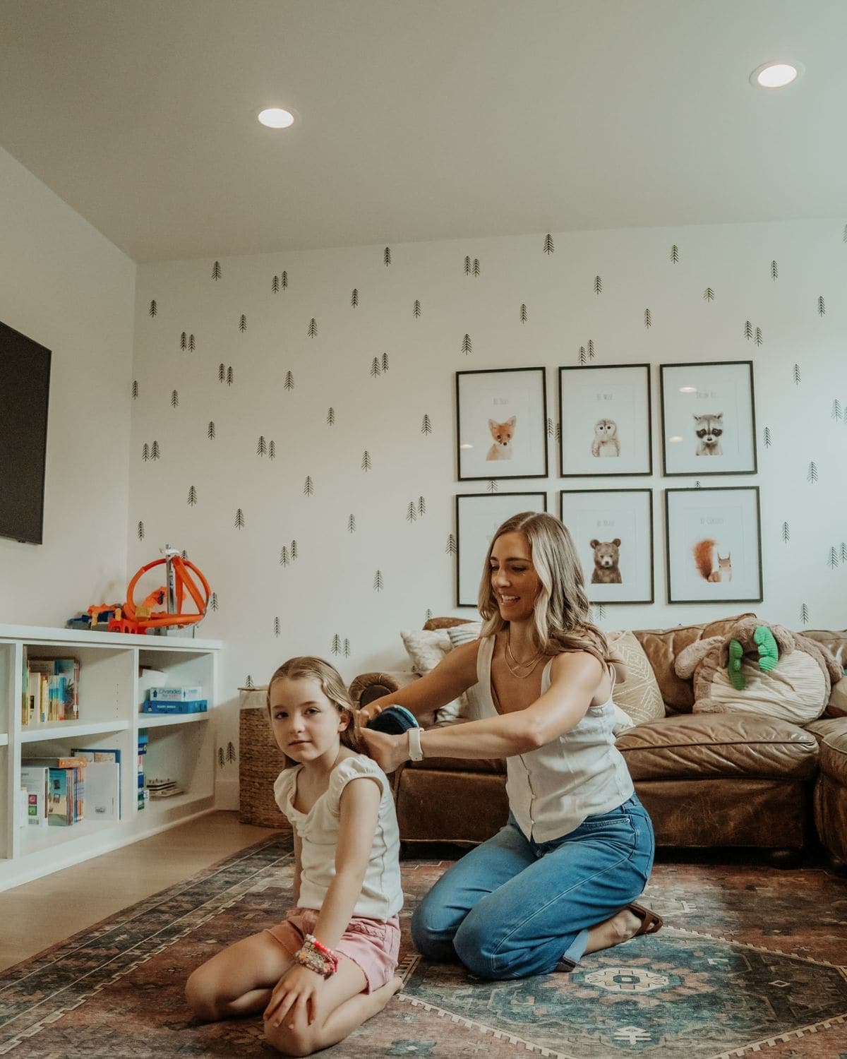 A parent braiding a daughter's hair in the playroom